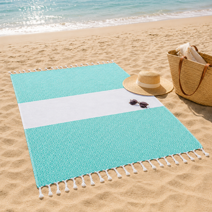 Turquoise striped towel laid flat on beach sand