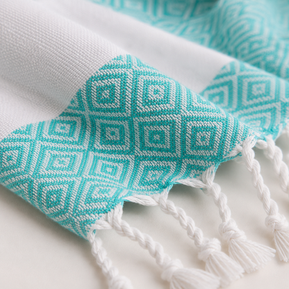 Close-up of turquoise geometric weave and knotted tassels